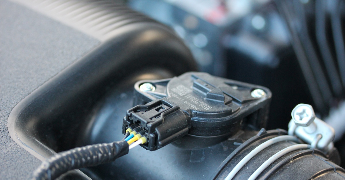 A black air intake sensor for a vehicle has wires attached to a hose inside an open engine compartment. A black air intake sensor for a vehicle has wires attached to a hose inside an open engine compartment.